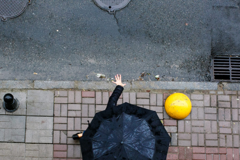 Left Hand out of Black Umbrella in Rain